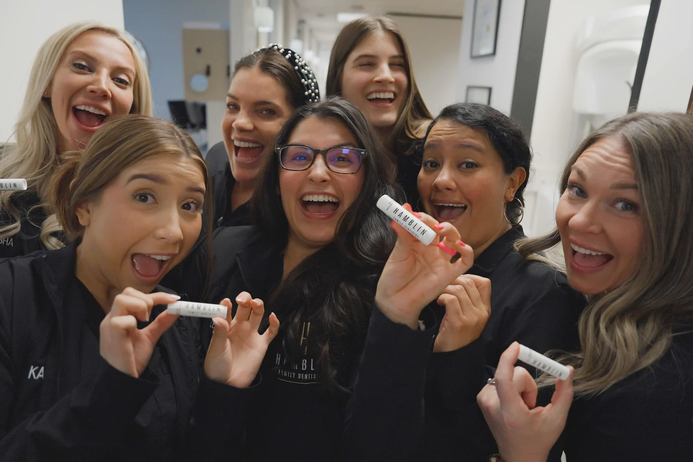 Hamblin team members laughing together with toothbrushes