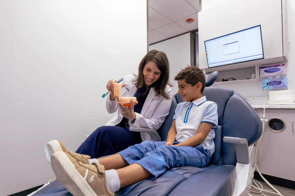 Dr. Saab helping a young patient learn about dental care